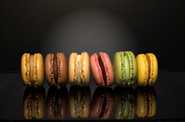 Delicious Sweet Colorful Macarons on black background