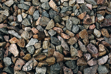 Old colorful stones rough background, many rocks near railway track