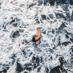 Surfeur avec sa planche de surf dans les vagues de l'océan en été