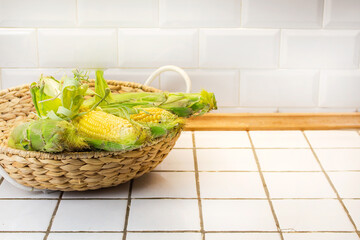 Organic fresh farm corn on the cob in basket with free copy space for text, frame of yellow corn maize mockup, flat lay view from above, autumn harvest