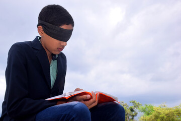 13 year old child with blindfold reading book, on the roof in the rainy season, Indecision and...