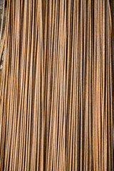 A metal rod of steel folded in a stack with traces of rust. Construction design, production backgrounds.