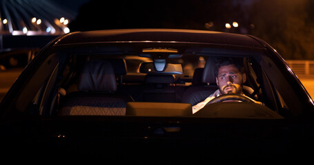 Upset young man sitting in car on parking lot © nimito