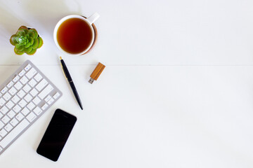 Working items with keyboard, phone, coffee and pen on table. 