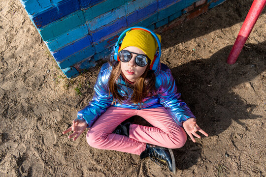 Teenage girl sits on the street a lotus position and meditates. Wellness concept.