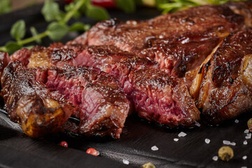 Closeup of sliced juicy veal steak with condiments and herbs
