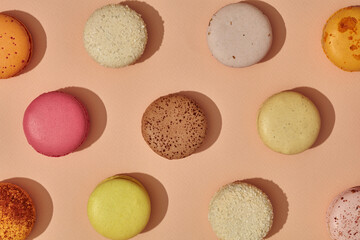 Top view of colorful macarons on light pink background