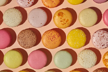 Top view of colorful macarons on pinkish background