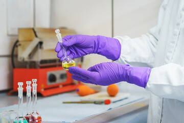 Hands of a chemical laboratory employee with test tubes close-up.