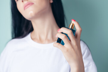 woman sprinkles perfume on her neck