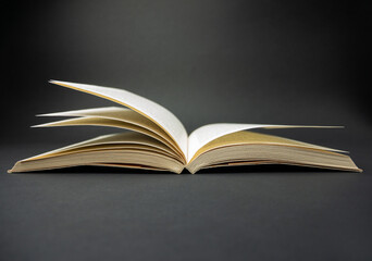 Open book on black background.