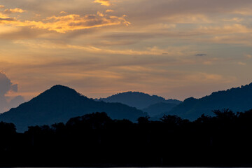 silhouette mountain with attractive background, sunset with vivid yellow sky