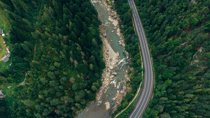 Fototapeta premium Beautiful aerial view of the road with mountains and forest, road and river, shot from above, carpathians, Ukraine