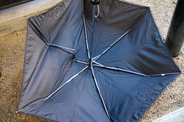骨の折れた折り畳みの黒い日傘