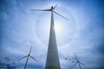The Halo effect is an optical phenomenon in the Earth's atmosphere that is observed around the Sun's disc. It is a rainbow-colored ring that is visible around the sun. Gaj Olawski wind farm. © promesaartstudio