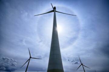 The Halo effect is an optical phenomenon in the Earth's atmosphere that is observed around the Sun's disc. It is a rainbow-colored ring that is visible around the sun. Gaj Olawski wind farm. © promesaartstudio