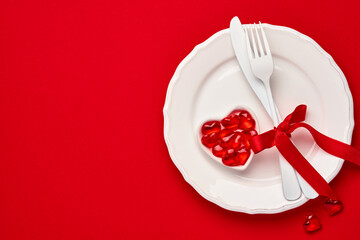 Valentines day background or concept with empty pink plate and whiteware on scarlet or red background. Top view flat lay with copy space.