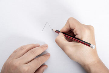 A woman's hand writes on a blank piece of paper