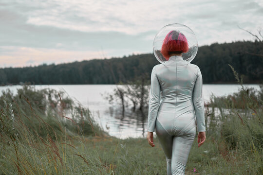 Woman in astronautic suit walking to water