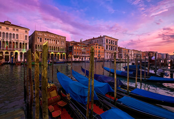 Fototapeta na wymiar Sunset view of Grand Canal, Venice, Italy. UNESCO heritage city famous for its waterways and gondolas, beautiful sunset sky and evening lights