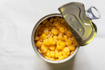 Sweet corn in can look delicious. Top view on marble background.