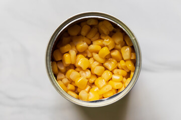 Sweet corn in can look delicious. Top view on marble background.