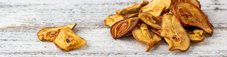 banner of A pile of dried pears in slices on a white wooden background. Dried fruit chips