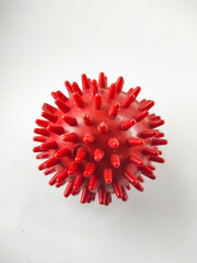 Photo of a spiked rubber ball resembling a virus isolated on a white background