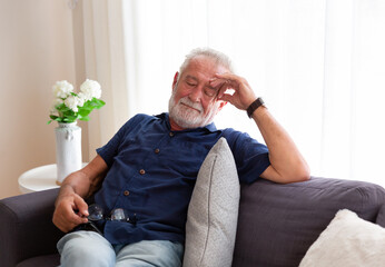 Senior man sleeping on sofa at home. Elderly man relaxing at home