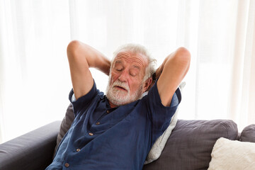 Senior man sleeping on sofa at home. Elderly man relaxing at home