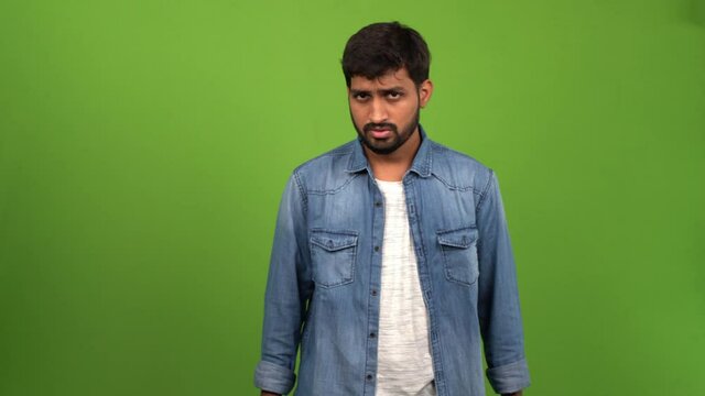 Netizen of Asian decent messaging happily over mobile phone; green screen shoot.