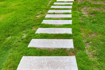 White granite walkway slabs patterned in green lawns at the garden