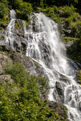 Fototapeta na wymiar Wasserfall mit Felsen und grünen Bäumen