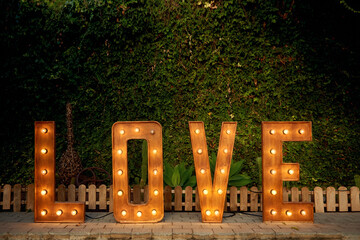 Illuminated love word in garden