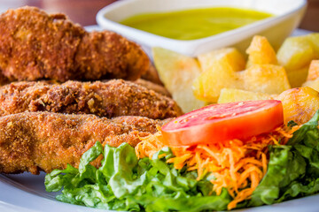 fingers de pollo con enslada, papas fritas y salsa mostaza 
