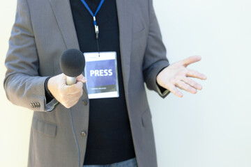 Journalist holding microphone, gesturing during media interview