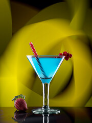 Blue cocktail of fruits on colorful lights background