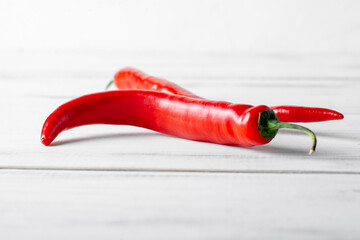 Red hot chili peppers on a white wooden background.