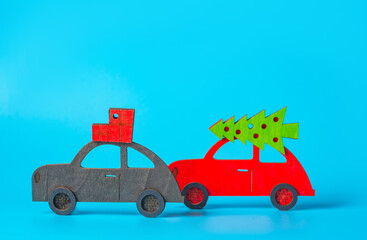 New year, christmas concept. Festive shopping. Several cars with Christmas decorations, Christmas trees on the roof on a blue background. Christmas background.