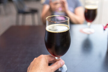 two glass of dark beer stands on a table in a bar or pub.Close-up.