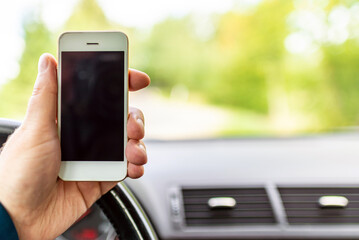 Man hand holding screen smart phone, blur on the road high way forest summer background.copy space,advertisement,banner.