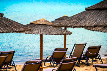 Beach umbrellas and deck chairs at the seaside in summer