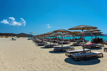 Beach umbrellas and deckchairs at the seaside in summer