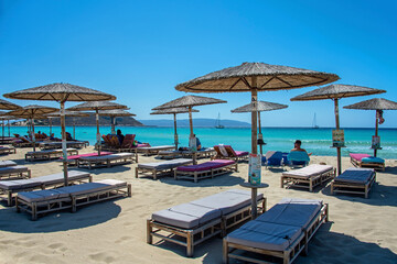 Fototapeta na wymiar Beach umbrellas and deckchairs at the seaside in summer