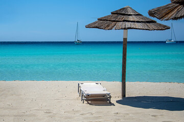 Beach umbrellas and deckchairs at the seaside in summer