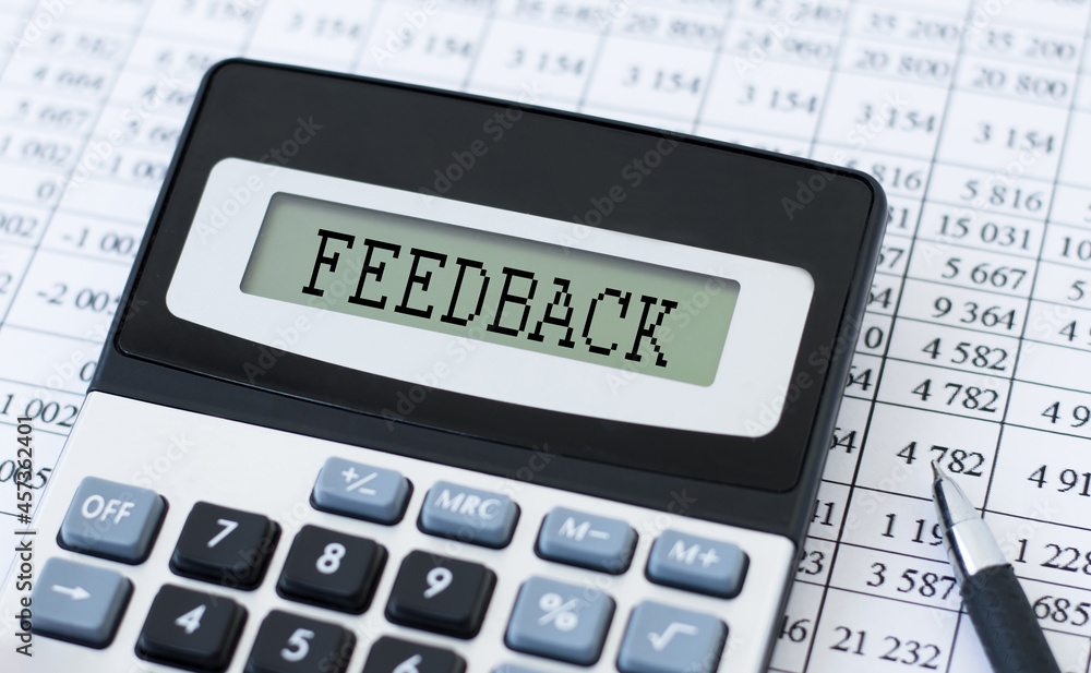 Poster calculator with text feedback on the table against the background of financial statements