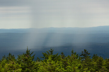 Fototapeta na wymiar Rain shower in the valley, seen from Mt. Kearsarge summit.