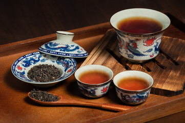 chinese traditional porcelain tea cup and tea leaf on wooden ancient board
