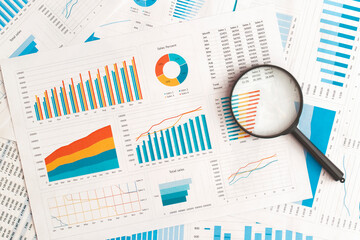 Business graphs, charts and magnifying glass on table. Financial development, Banking Account, Statistics - obrazy, fototapety, plakaty