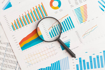 Business graphs, charts and magnifying glass on table. Financial development, Banking Account, Statistics - obrazy, fototapety, plakaty